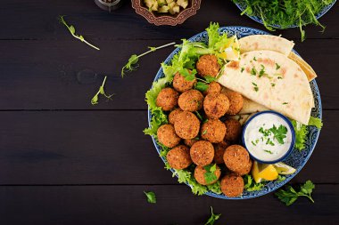 Falafel, humus ve pide. Karanlık bir arka plan üzerinde Orta Doğu ya da Arap yemekleri. Helal Gıda. Üstten Görünüm. Kopya alanı