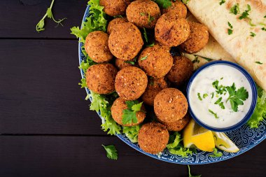 Falafel, humus ve pide. Karanlık bir arka plan üzerinde Orta Doğu ya da Arap yemekleri. Helal Gıda. Üstten Görünüm. Kopya alanı