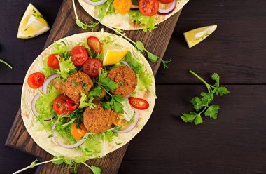 Falafel ve taze salata tortilla sarın. Vegan Taco. Vejetaryen sağlıklı yiyecekler. Üstten Görünüm