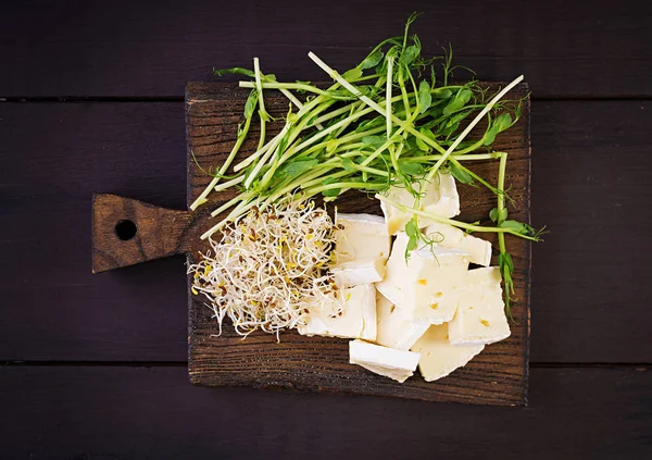 Měkký sýr brie a microgreens na dřevěném prkénku — Stock fotografie