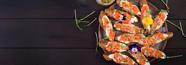 Salmon sandwiches with cream cheese and microgreen on wooden tab — Stock Photo, Image