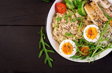 Taze salata. Yulaf ezmesi, tavuk fileto, domates, marul, microgreens ve haşlanmış yumurta ile Kahvaltı kase. Sağlıklı yiyecekler. Vejetaryen buda kase. Üstte görüntü
