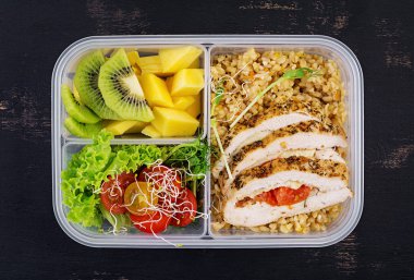 Öğle yemeği kutusu tavuk, bulgur, microgreens, domates ve meyve. Sağlıklı fitness yemekleri. Al. Lunchbox. Üstte görüntü