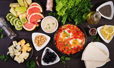 Türk Kahvaltısı - shakshuka, zeytin, peynir ve meyve. Zengin brunch. Üstte görüntü