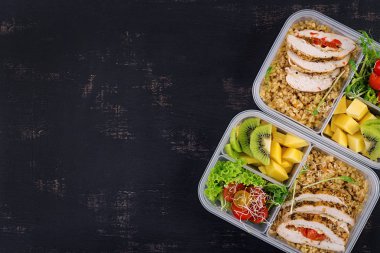 Öğle yemeği kutusu tavuk, bulgur, microgreens, domates ve meyve. Sağlıklı fitness yemekleri. Al. Lunchbox. Üstte görüntü