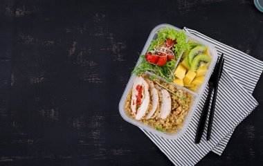 Öğle yemeği kutusu tavuk, bulgur, microgreens, domates ve meyve. Sağlıklı fitness yemekleri. Al. Lunchbox. Üstte görüntü