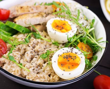 Taze salata. Yulaf ezmesi, tavuk fileto, domates, marul, microgreens ve haşlanmış yumurta ile Kahvaltı kase. Sağlıklı yiyecekler. Vejetaryen buda kase.