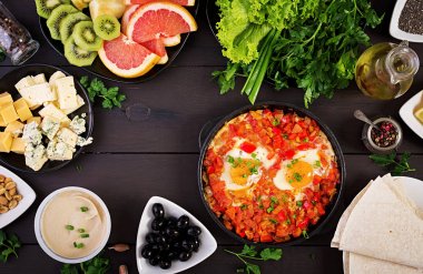Türk Kahvaltısı - shakshuka, zeytin, peynir ve meyve. Zengin brunch. Üstte görüntü