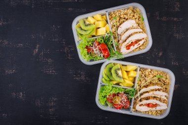 Öğle yemeği kutusu tavuk, bulgur, microgreens, domates ve meyve. Sağlıklı fitness yemekleri. Al. Lunchbox. Üstte görüntü