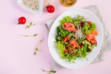 Diyet menüsü. Taze sebze Sağlıklı salata - domates, avokado, arugula, tohum ve somon bir kase üzerinde. Vegan yemek. Düz yatıyordu. Üstte görüntü
