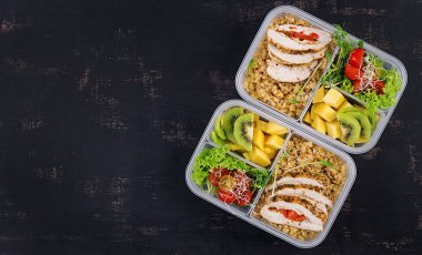 Öğle yemeği kutusu tavuk, bulgur, microgreens, domates ve meyve. Sağlıklı fitness yemekleri. Al. Lunchbox. Üstte görüntü