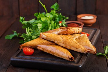 Asya yemekleri. Samsa (samosas) ahşap arka plan üzerinde tavuk fileto ve peynir ile.