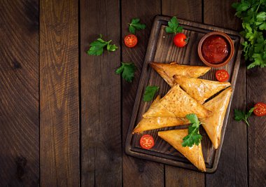 Asya yemekleri. Samsa (samosas) ahşap arka plan üzerinde tavuk fileto ve peynir ile. Üstte görüntü