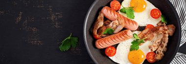 İngiliz kahvaltısı - kızarmış yumurta, domates, sosis ve pastırma. Sayfanın Üstü 