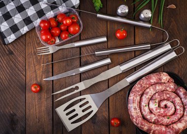 Barbekü Araçları ve ahşap masa üzerinde sosis. Düz döşeme, üst görünüm