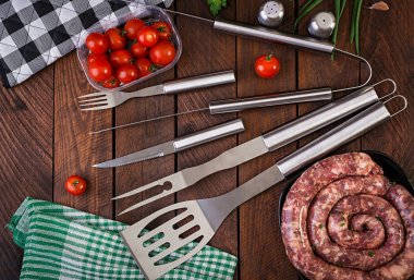 Barbekü Araçları ve ahşap masa üzerinde sosis. Düz döşeme, üst görünüm