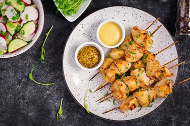 Izgara tavuk kebap ve salatalık, turp, koyu bir arka plan üzerinde soğan ile salata. Kopya alanı. Üstte görüntü