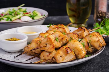 Izgara tavuk kebap ve salatalık ile salata, turp, koyu bir arka plan soğan.