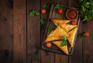 Asya yemekleri. Samsa (samosas) ahşap arka plan üzerinde tavuk fileto ve peynir ile. Üstte görüntü