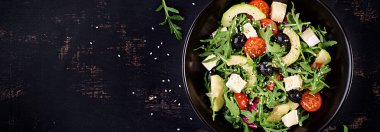 Dilimlenmiş avokado ile yeşil salata, kiraz domates, siyah zeytin a