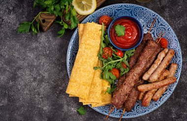 Türk ve Arap Geleneksel Ramazan karışımı kebap tabağı. Kebap adana, domates soslu lavaş ekmeği üzerine kuzu ve dana eti. Üstte görüntü