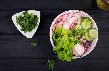 Salatalık, turp, soğan ve otlar taze salata. Buda kase. Düz yatıyordu. Üstte görüntü
