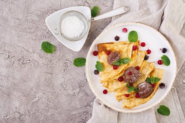 Nane yaprağı ile süslenmiş çilek ve çikolata ile krep. Lezzetli kahvaltı. Üstte görüntü