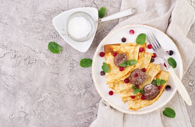 Nane yaprağı ile süslenmiş çilek ve çikolata ile krep. Lezzetli kahvaltı. Üstte görüntü