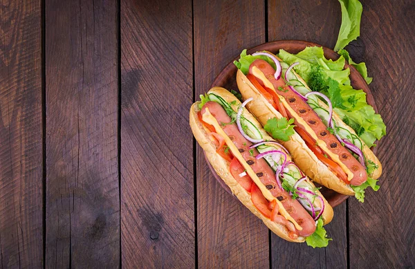 Hot Dog Con Salsiccia Cetriolo Pomodoro Lattuga Fondo Legno Scuro — Foto Stock