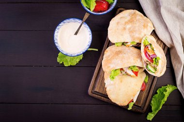 Pide tavuk, domates ve marul ahşap arka plan ile doldurulmuş. Orta Doğu mutfağı. Üstte görüntü