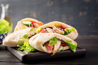 Pide tavuk, domates ve marul ahşap arka plan ile doldurulmuş. Orta Doğu mutfağı.