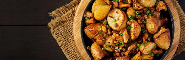 Gebackene Kartoffeln mit Knoblauch, Kräutern und gebratenen Pfifferlingen in einem ca. — Stockfoto