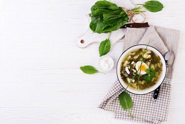 Beyaz kasede yeşil sorrel çorbası. Düz yatıyordu. Üstte görüntü