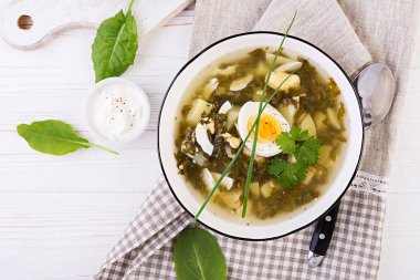 Beyaz kasede yeşil sorrel çorbası. Düz yatıyordu. Üstte görüntü