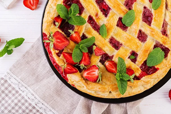 American strawberry pie tart cake sweet baked pastry food on white wooden table. Top view