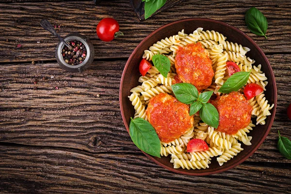 トマトソースとバジルのミートボールをボウルに入れたフシリパスタ イタリア料理トップビュー フラットレイ — ストック写真