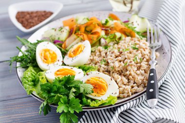 Yulaf ezmesi, kabak, marul, havuç ve haşlanmış yumurta ile kahvaltı kase. Taze salata. Sağlıklı yiyecekler. Vejetaryen buda kase.