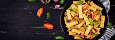 Tavuk eti ile Rigatoni makarna, kase domates sosu patlıcan. İtalyan mutfağı. Üst görünüm. Afiş