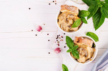 Tencere içinde tavuk, peynir ve tost ile pişmiş mantar Julienne. Üst görünüm