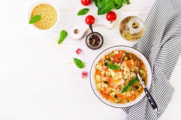 ミネストローネ 白いテーブルにパスタとイタリアの野菜スープ ビーガンスープトップビュー — ストック写真