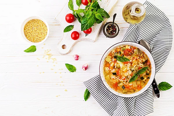 ミネストローネ 白いテーブルにパスタとイタリアの野菜スープ ビーガンスープトップビュー — ストック写真