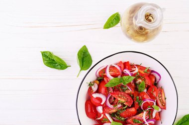 Fesleğen ve kırmızı soğan ile Domates salatası. Ev yapımı yemekler. Kavram sağlıklı yemek. Vegan mutfağı. Üstte görüntü