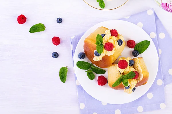 ホイップクリームと新鮮なラズベリー ブルーベリーで飾られたラムババ クリーム ベリーのサヴァリン イタリア料理トップビュー — ストック写真