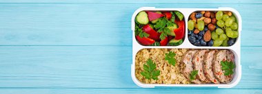 Öğle yemeği kutusu köfte, bulgur, fındık, salatalık ve meyve. Sağlıklı fitness yemekleri. Al. Lunchbox. Üstte görüntü