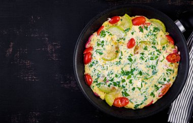 Domatesli omlet, kabak ve koyu masada kırmızı soğan. Frittata - İtalyan omlet. Üstte görüntü