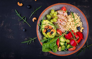 Buddha bowl dish with meatloaf, bulgur, avocado, sweet pepper, tomato, cucumber, berries and nuts. Detox and healthy superfoods bowl concept. Overhead, top view, flat lay clipart