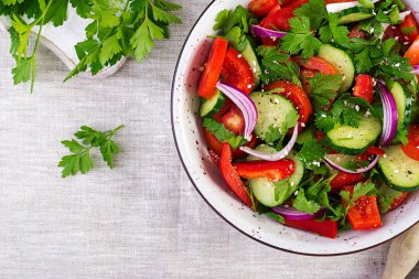 Kırmızı soğan, kırmızı biber, karabiber ve maydanoz ile domates ve salatalık salatası. Vegan yemek. Diyet menüsü. Üst te. Düz yatıyordu