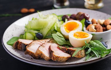 Ketojenik diyet. Keto brunch' ı. Haşlanmış yumurta, domuz biftek ve zeytin, salatalık, ıspanak, tuzlu peynir, fındık ve yaban mersini.
