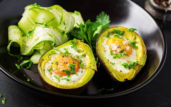 Avocado baked with egg and fresh salad. Vegetarian dish.  Ketogenic diet. Keto food