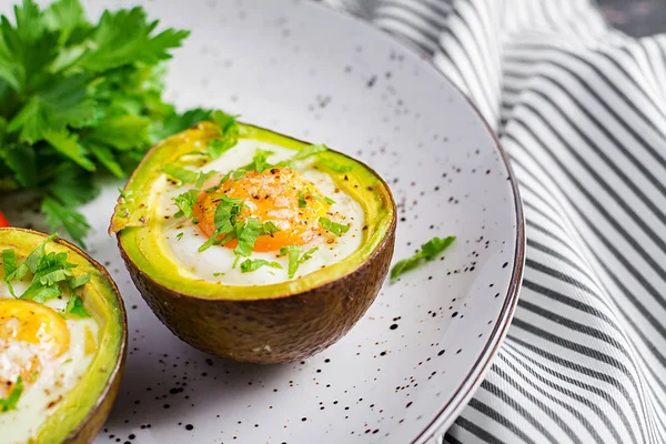 Avocado baked with egg and fresh salad. Vegetarian dish. Ketogenic diet. Keto food